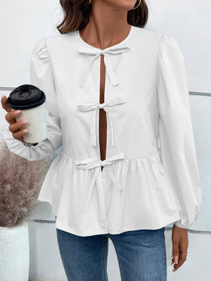 White peplum blouse with keyhole neckline and bow details.