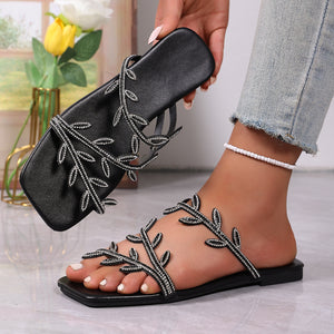 Black rhinestone leaf embellished open toe flat sandals with square toe.