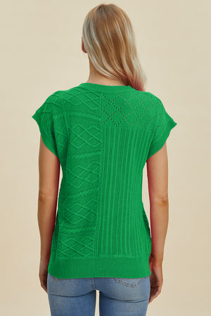 Green knit patchwork top with cable and diamond stitch details, short sleeves.