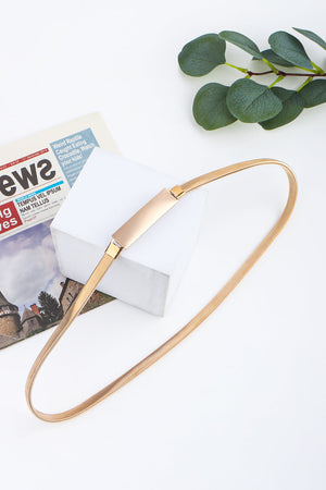 Slimline gold-tone metal waist belt with a rectangular buckle.