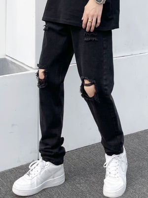 Black distressed slim fit jeans made of 100 cotton with ripped details.