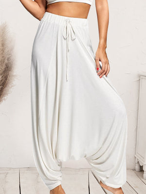 White drape-front drawstring harem pants with a relaxed fit.