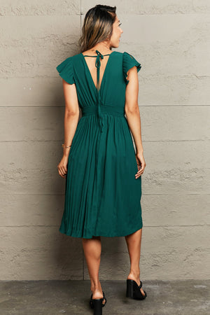 Dark Green pleated midi dress with flutter sleeves and a tie-back V-neck.