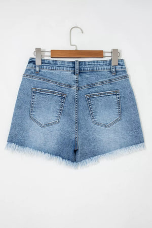 Blue denim shorts with distressed details and frayed hem