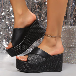 Black open-toe wedge sandals with glitter embellishment and cross-over straps.