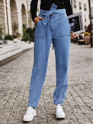 Belted high-waist light wash denim barrel trousers with front pockets.