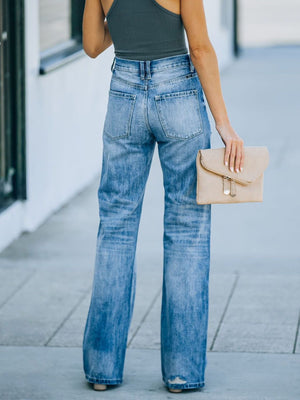 Wide-leg distressed denim jeans in dusty blue with a high rise, styled casually.