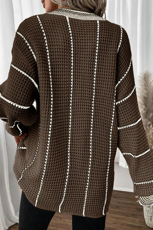Brown knit oversized V-neck dress with white vertical stripes and waffle texture.
