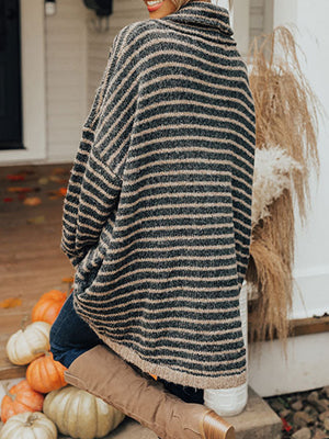 Oversized striped turtleneck sweater in black and tan with slouch pockets.