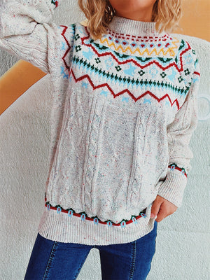 Beige cable knit turtleneck sweater with Fair Isle pattern and flecks of color.