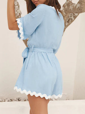 Blue linen romper with scalloped edges and tie waist, short sleeves