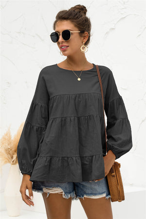 Black tiered peasant blouse with long bubble sleeves and round neckline.