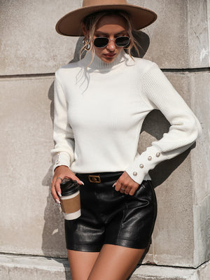 White turtleneck knit sweater with pearl button cuff details