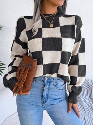 Checkerboard knit mock neck pullover sweater in black and cream acrylic with ribbed cuffs.