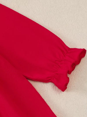 Red baby dress with long sleeves and ruffled cuffs.