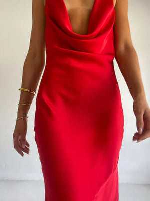 Red satin halter maxi dress with cowl neck and asymmetric hem, body skimming fit.