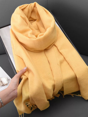 Yellow fringed scarf with a soft texture, perfect for versatile styling.