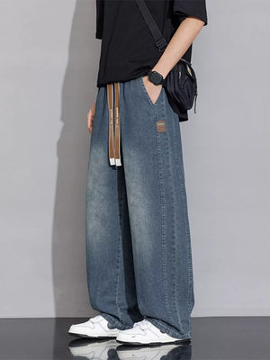 Relaxed vintage wash wide-leg jeans in gray blue denim with drawstring waist and patch detail.