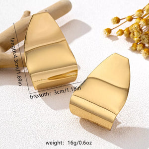 Golden alloy geometric earrings with a wavy, sculpted design.