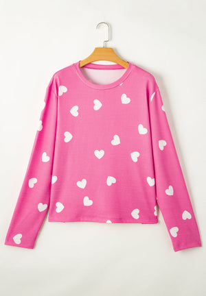 Hot pink long sleeve top with white hearts pattern, round neck.