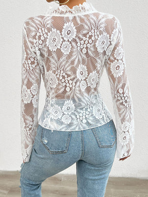 White lace blouse with floral pattern and ruffled neckline, long sleeves.