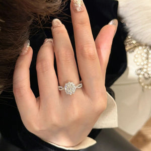 Sterling silver moissanite halo ring with oval center stone and twisted band.