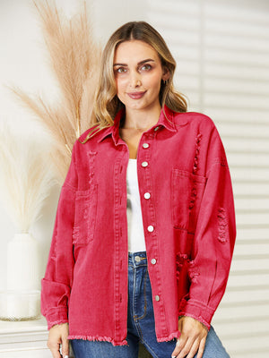 Distressed denim overshirt in orange-red with raw hem and button front.