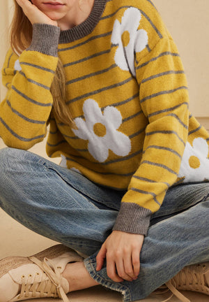 Yellow knit sweater with grey stripes and white daisy intarsia pattern, crew neck, long sleeves.