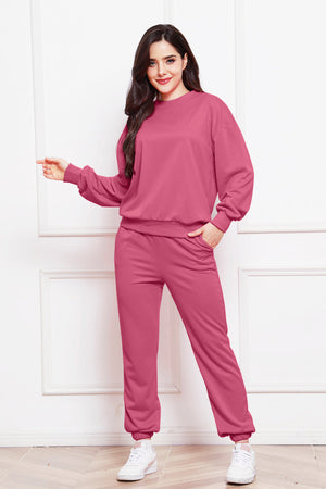 Relaxed fit loungewear set in hot pink, featuring a crewneck sweatshirt and jogger pants with pockets.