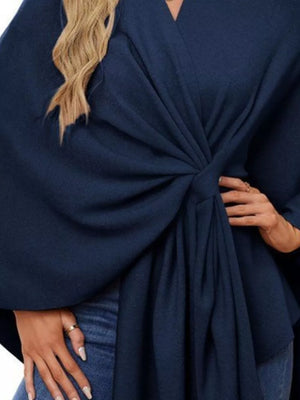 Navy knit cape top with tie-front detail and draped elegance.