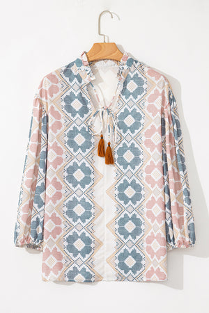 Floral geometric print blouse with tassel tie neckline and ruffled collar.