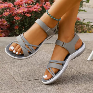 Gray open-toe sandals with criss-cross straps and adjustable ankle strap.