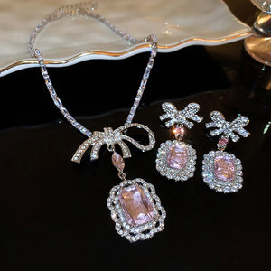 Silver bow crystal drop earrings with pink gemstone pendants and matching necklace.