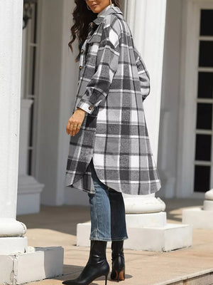 Plaid longline trench coat in grey with button-down front and pockets, worn open over jeans.