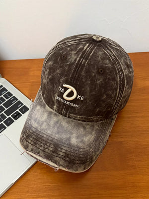Embroidered vintage denim baseball cap in brown with distressed details and white text.