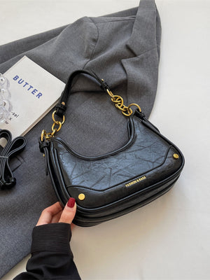 Black crescent shoulder bag with chunky chain accent and textured finish.