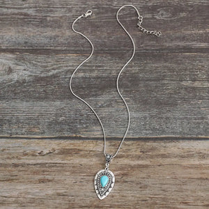 Silver teardrop necklace with turquoise inlay pendant and boho detailing.