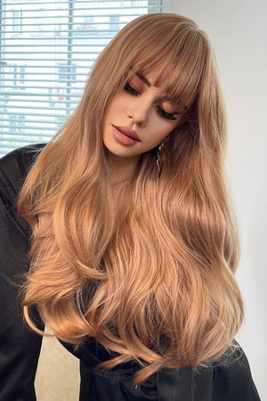 Strawberry blonde wig with bangs and loose waves, styled with a black top.