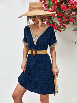Dark blue Swiss dot dress with crochet trim and ruffled hem.