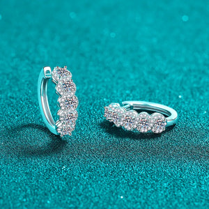 Silver moissanite cluster huggie hoop earrings with five sparkling stones each.