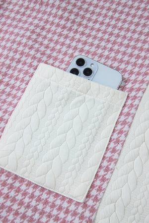 Panelled houndstooth shacket in dusty pink with quilted pocket detail and a phone.