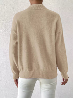 Khaki mock neck knit sweater with dropped shoulders and ribbed cuffs and hem.