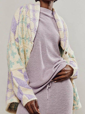 Geometric patchwork knit cardigan in cream with purple and green diamond pattern.