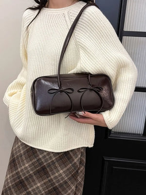 Chocolate patent leather shoulder bag with double bow detail.