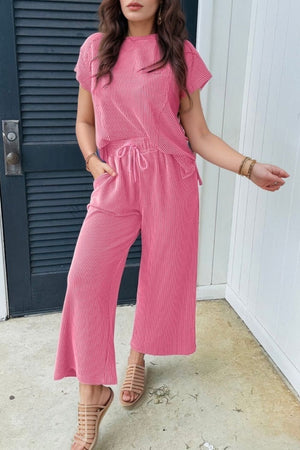 Fuchsia pink ribbed knit drawstring co-ord set with wide leg pants and short sleeve top.