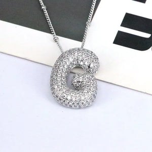 Silver pave initial bubble pendant necklace with a delicate chain.