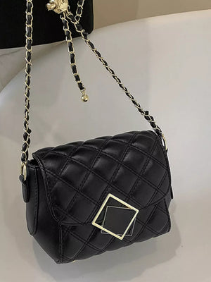 Black quilted crossbody bag with gold chain strap and square charm detail.