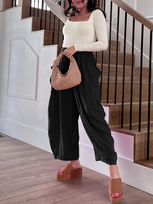 Black linen balloon trousers with cargo pockets and a relaxed fit.