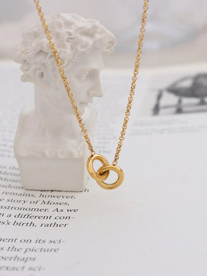 Gold interlocked circle pendant necklace with a sculptural design.