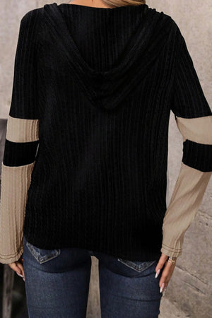 Colorblock ribbed zip-neck hoodie in black with beige and black striped sleeves.